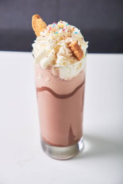 Soğuk çikolata milkshake frappe cam kafede masada Close-up. Yaz tatlı içeceği.