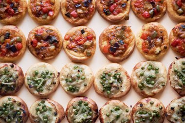 Birçok taze pişmiş mini pizza cocas. Sebze ile geleneksel İspanyol pasta. Üstten görünüm.