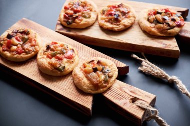 Geleneksel İspanyolca Close-up mini pizza cocas ahşap tahta üzerinde pişmiş. Siyah arka plan.