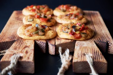 Ahşap tahta üzerinde birçok taze pişmiş mini pizza cocas. Sebze ile geleneksel İspanyol pasta.