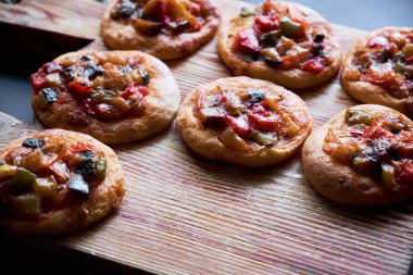 Ahşap tahta üzerinde birçok taze pişmiş mini pizza cocas. Sebze ile geleneksel İspanyol pasta.