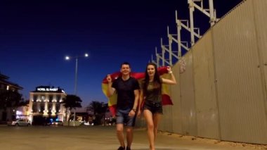 Ağır çekim Genç mutlu kadın ve İspanya kazanmak kutluyor kameraya doğru İspanyol bayrağıyla koşan adam.