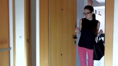 Gözlük ve dairesini, kapılarını açıyor resmi kıyafet giyen genç çekici kadın eve yorgun işten, çanta ve anahtarları yere atma ve crouching.