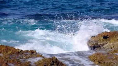 Deniz dalgaları kayalarda kırılıyor.