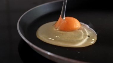 Kırma ve kahvaltı için bir tavada bir yumurta bırakarak yakın çekim. Ağır çekim, 4k.