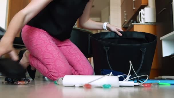 Молодая женщина кладет вещи в сумку — стоковое видео