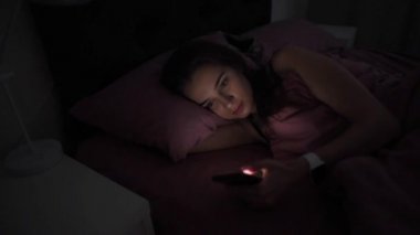 Cep telefonu gece yatakta olan kadın
