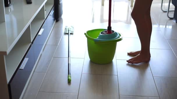 Jeune femme essuyant sol carrelage blanc avec serpillière à la maison — Video