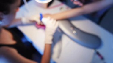 Çivi Master bulanık görüntü müvekkili için manikür yapıyor ve yaralanma yaptıktan sonra cilt alkol ile dezenfekte tek kullanımlık eldiven eller. Ağır çekim.