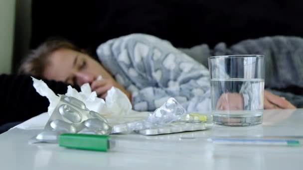 自宅のソファーに横になっている 大きく咳をテーブルと水を飲んで薬を探して若い病気の女性のクローズ アップ — ストック動画