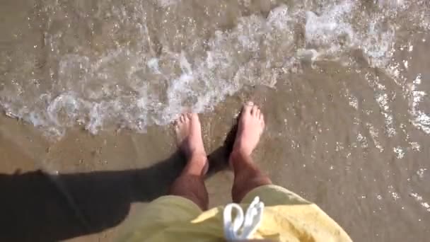 Manliga fötter på stranden vid havet — Stockvideo