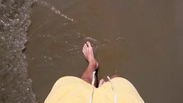 Manliga fötter på stranden vid havet — Stockvideo