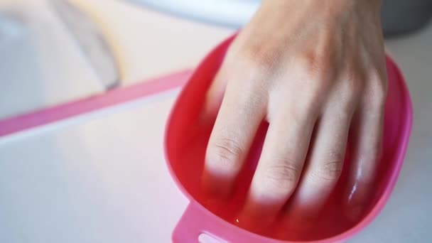 Женская рука в миске с водой перед маникюром — стоковое видео