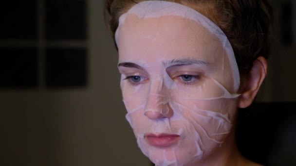 Ung kvinna med ansiktsbehandling sheet mask — Stockvideo
