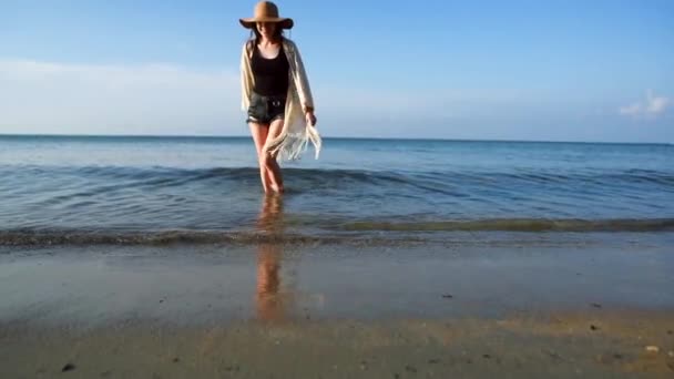 Mujer joven con sombrero de paja disfrutando y bailando junto al mar — Vídeo de stock