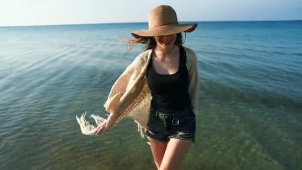 Mujer joven con sombrero de paja disfrutando y bailando junto al mar — Vídeo de stock