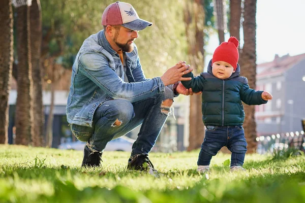 在阳光明媚的日子里 可爱快乐的小男孩牵着父亲的手在公园散步 父亲和儿子 — 图库照片