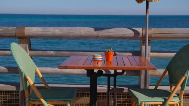 海の上の美しい景色と居心地の良いビーチ カフェ 木製のテーブルと椅子の海の海岸によって クライアントの準備 — ストック動画