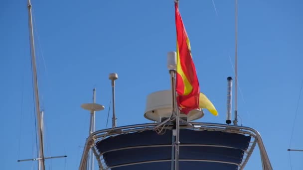 在豪华游艇的顶部挂着一面巨大的西班牙国旗 阳光明媚的夏季天气 蓝色西班牙天空 — 图库视频影像