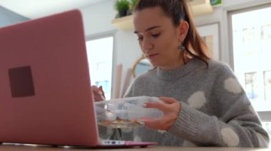 Bir dizüstü bilgisayarda çalışan meşgul genç kadın