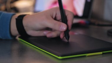Bilgisayarda dijital çizim tableti ve kalemle çalışan grafik tasarımcının yakın çekimi. Grafik tablet ile evde çalışan freelancer.