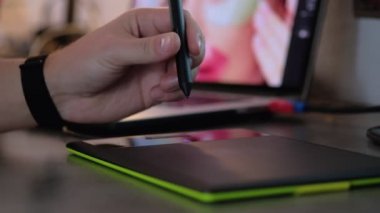 Bilgisayarda dijital çizim tableti ve kalemle çalışan grafik tasarımcının yakın çekimi. Grafik tablet ile evde çalışan serbest rötuş.
