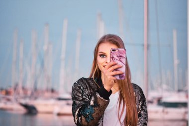 Mutlu güzel sarışın kadın bir akıllı telefon ile fotoğraf çekmek