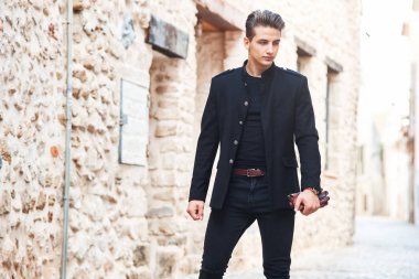Siyah elbiseli genç yakışıklı adam.