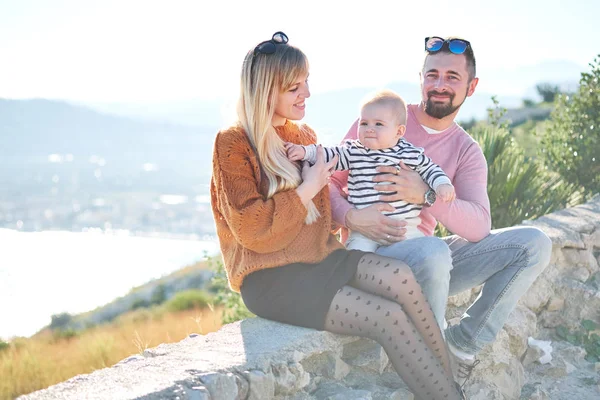 Retrato de feliz jovem família com pouco bonito menino aproveitando o dia ensolarado pelo mar — Fotografia de Stock