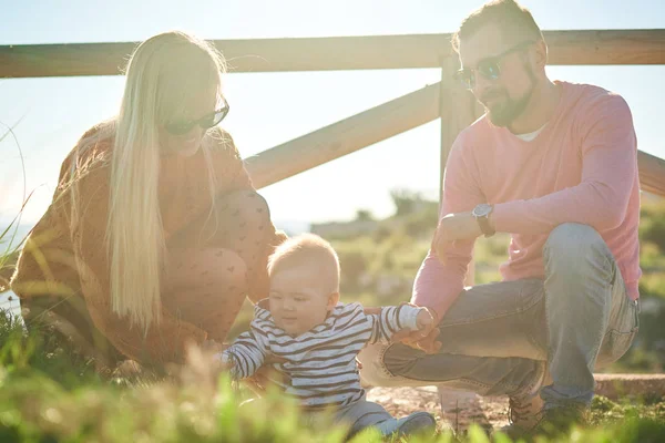 Ritratto di giovane famiglia felice con piccolo ragazzo carino godendo la giornata di sole — Foto Stock