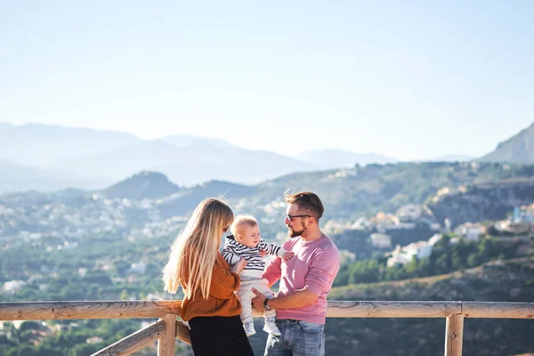 Felice giovane famiglia con piccolo ragazzo carino godendo la giornata di sole — Foto Stock