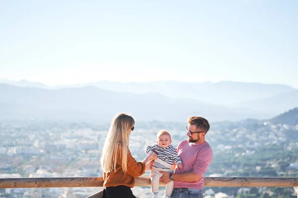 Glückliche junge Familie mit kleinem netten Jungen genießt den sonnigen Tag — Stockfoto