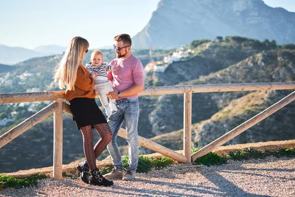 Felice giovane famiglia con piccolo ragazzo carino godendo la giornata di sole — Foto Stock