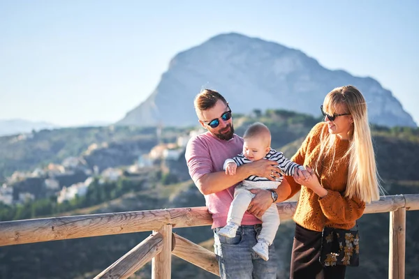 Felice giovane famiglia con piccolo ragazzo carino godendo la giornata di sole — Foto Stock