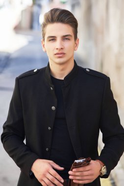Siyah elbiseli genç yakışıklı adam.