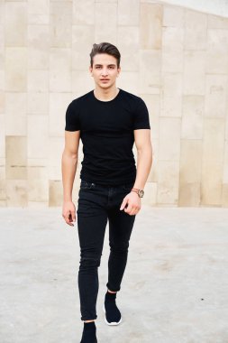 Siyah giysiler giyen yakışıklı genç adam