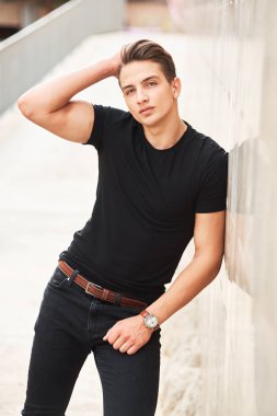 Siyah giysiler giyen yakışıklı genç adam
