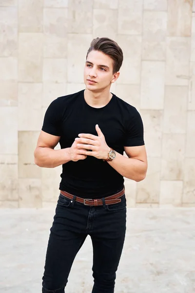 Siyah giysiler giyen yakışıklı genç adam
