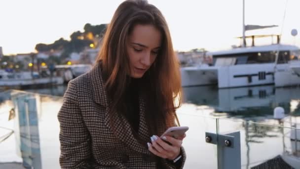 彼女の携帯電話で夕暮れ時の素敵な海の景色のビデオを記録するボートの若い魅力的な女性の肖像画 デニア スペイン — ストック動画