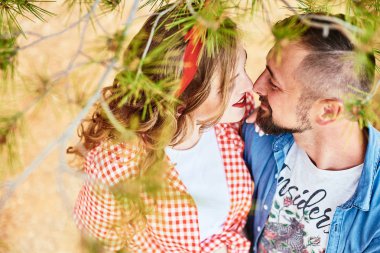 Kocasıyla parkta poz veren hamile bir kadın.