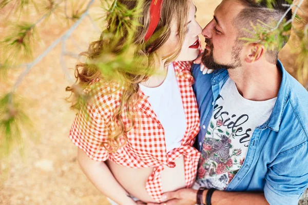 Jeune femme enceinte posant avec son mari dans un parc — Photo