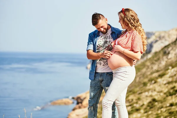 Young pregnant woman walking with her husband against sea background — Stock Photo, Image