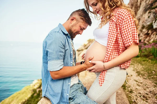 Young man looking at his pregnant wife's belly — Stock Photo, Image