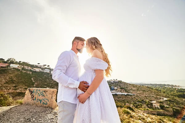 Young pregnant woman posing with her husband on a sunny summer day — 스톡 사진