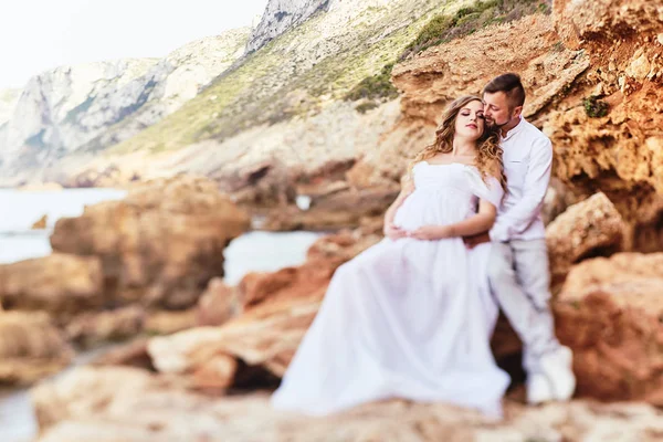 Young pregnant woman posing with her husband on the beach — 스톡 사진