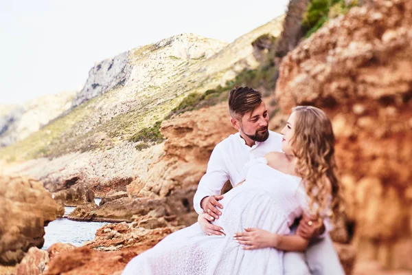 Young pregnant woman posing with her husband on the beach — 스톡 사진