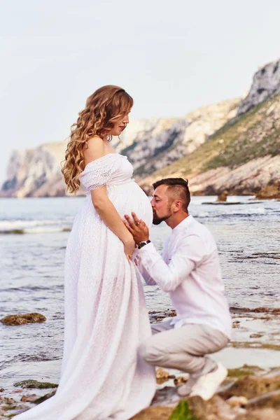 Jeune homme embrassant le ventre de sa femme enceinte — Photo