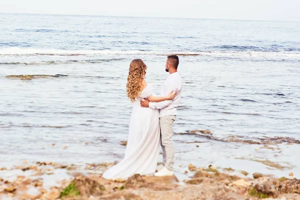 Young pregnant woman posing with her husband on the beach — 스톡 사진