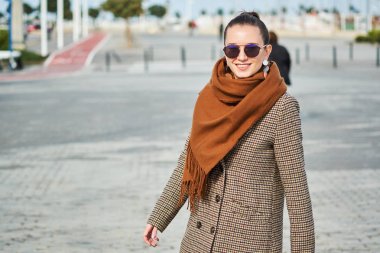 Sokakta yürüyen ve mesajlaşan genç bir kız.