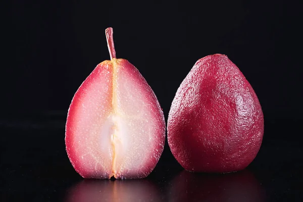 Close-up of a pear in red wine isolated on black background